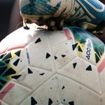 Close-up of a football boot on a match ball on the pitch